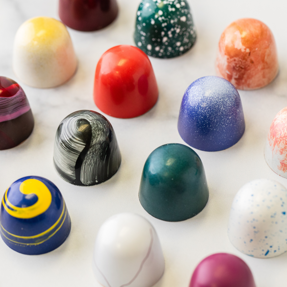 Sixteen hand-painted Winfield's signature truffles spread across a marble surface