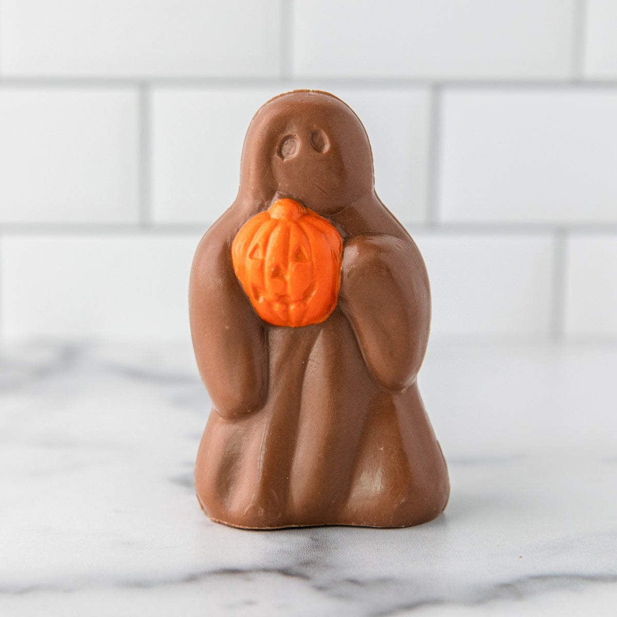 Winfield's milk chocolate Ghost holding an orange jack-o'-lantern pumpkin