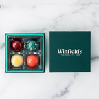 Winfield's Signature Truffle Collection 4-piece box open on marble, teal tray beside the dark green lid