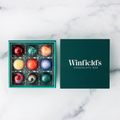 Winfield's Signature Truffle Collection 9-piece box open on marble, teal tray beside the dark green lid