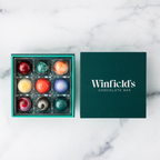 Winfield's Signature Truffle Collection 9-piece box open on marble, teal tray beside the dark green lid