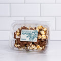 Wide clear tub of Winfield's Milk Chocolate Popcorn
