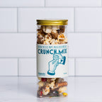 Tall glass jar with a gold lid filled with Winfield's Crunch Mix