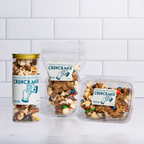 The Winfield's Crunch Mix range — glass jar, stand-up pouch and clear tub — on a marble counter
