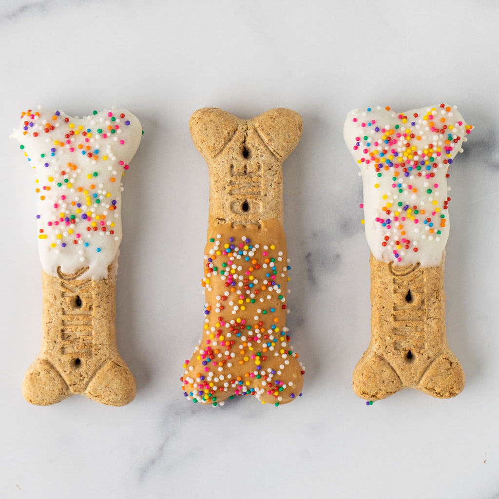 Three Winfield's large dog-bone biscuits finished with yogurt coating and rainbow sprinkles