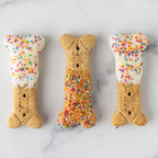Three Winfield's large dog-bone biscuits finished with yogurt coating and rainbow sprinkles