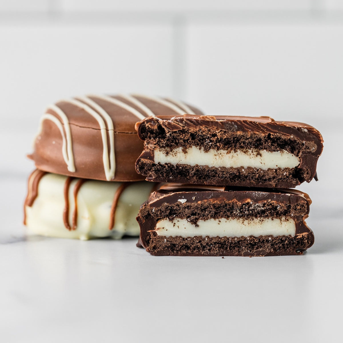 Winfield's chocolate-covered Oreos stacked, one cut open to show the cookie inside