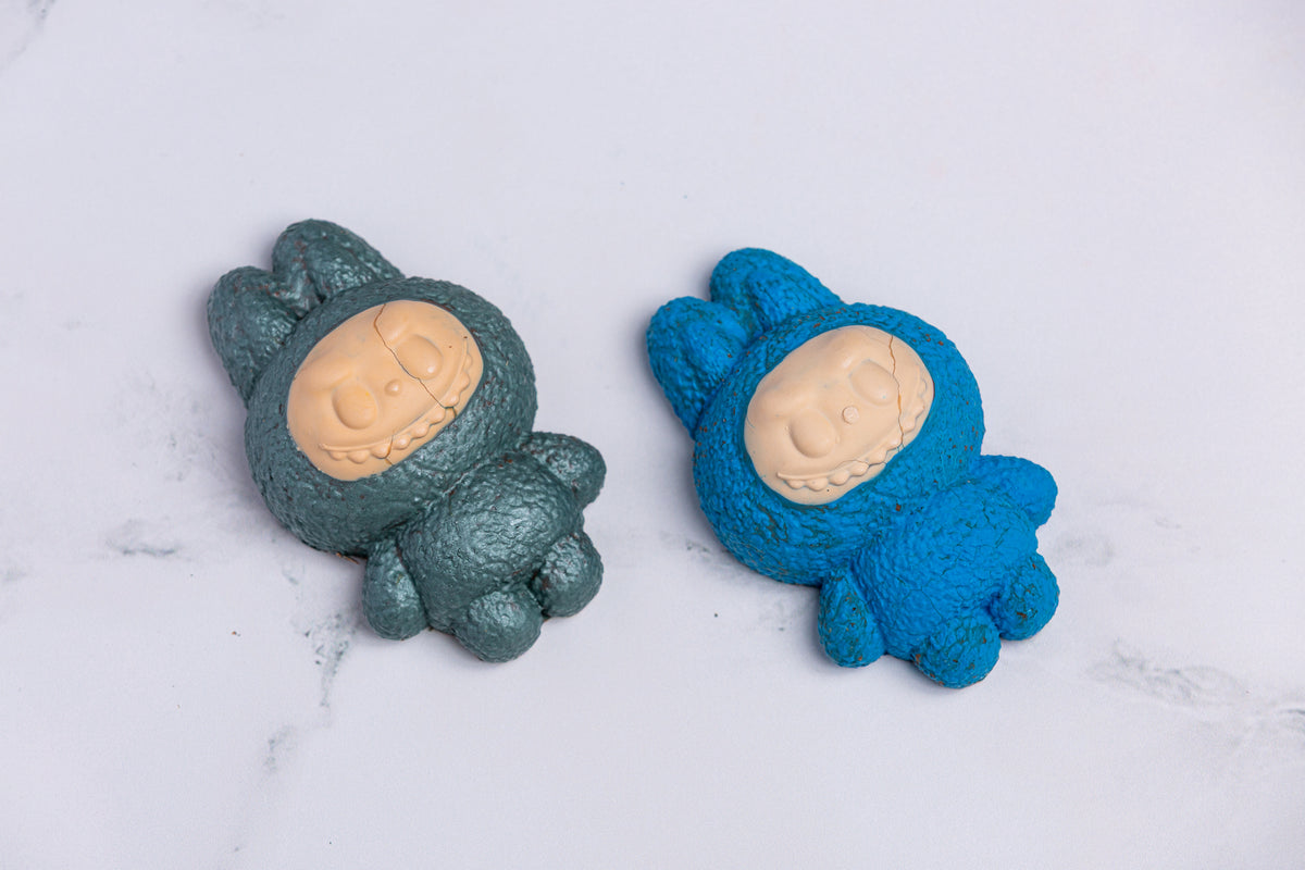Two Winfield's molded chocolate Labubu figures in teal and blue, on marble