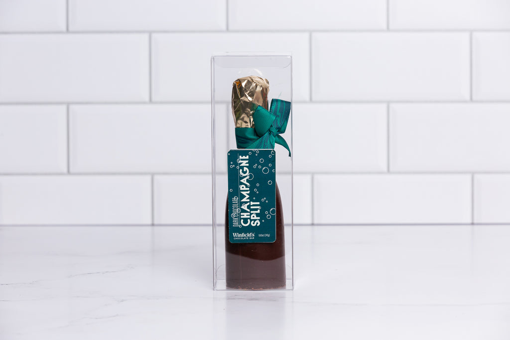 Winfield's dark chocolate champagne split in a clear box with a gold foil neck and green bow