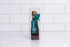 Winfield's dark chocolate champagne split in a clear box with a gold foil neck and green bow