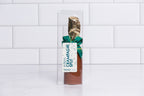 Winfield's milk chocolate champagne split in a clear box with a gold foil neck and green bow