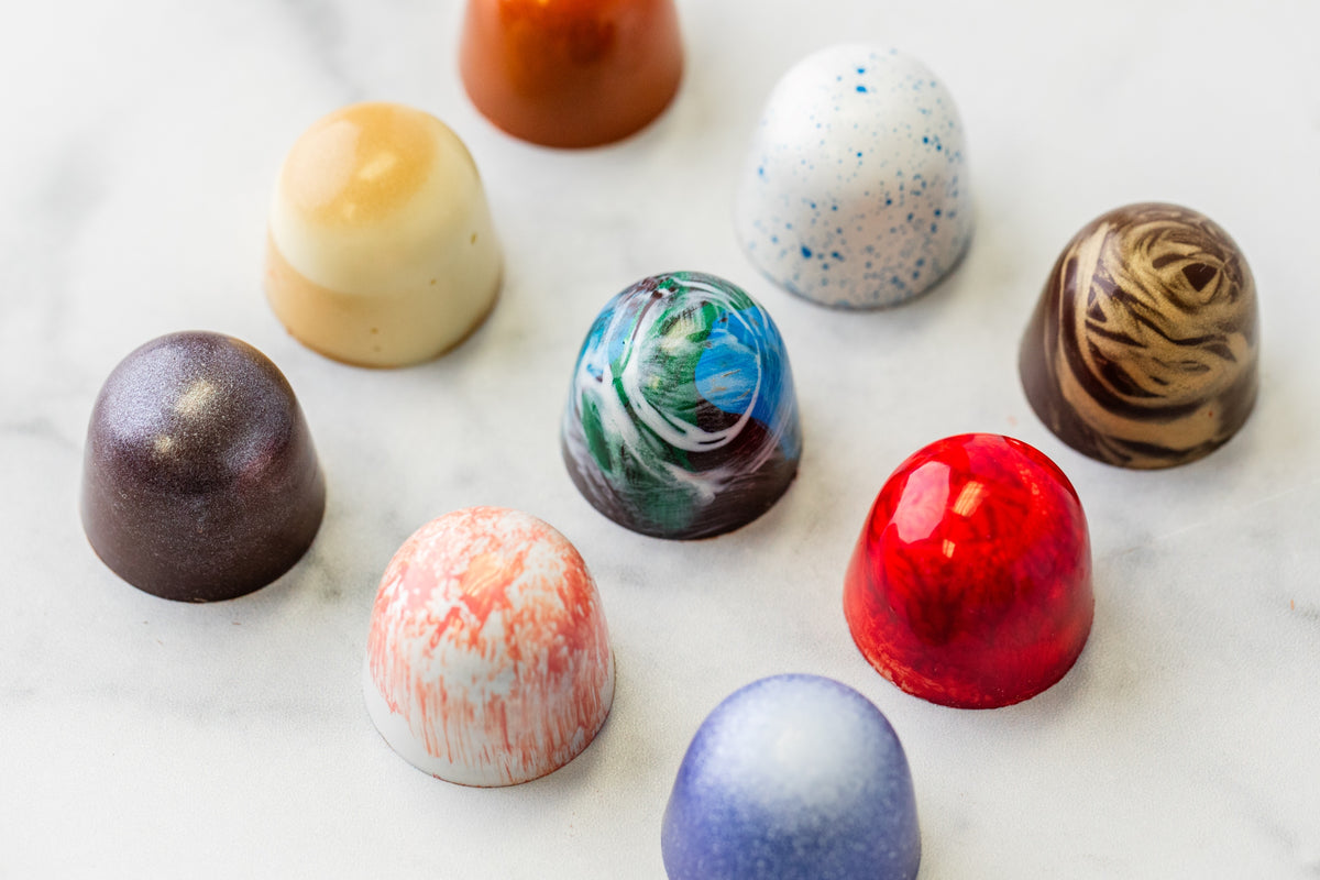 Nine Winfield's Space City truffles hand-painted with planet and galaxy finishes