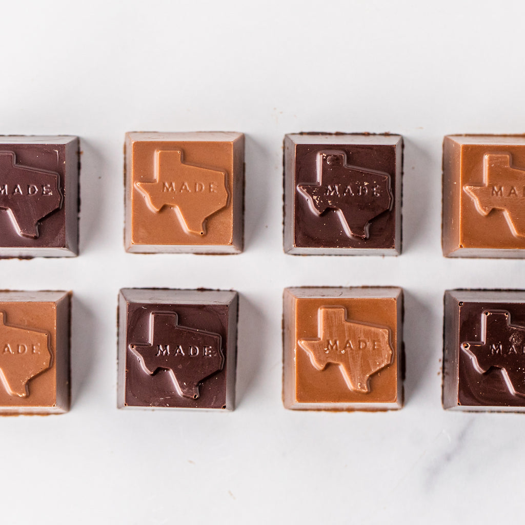 Eight Winfield's Texas-Made Caramels in milk and dark chocolate, each embossed with the outline of Texas