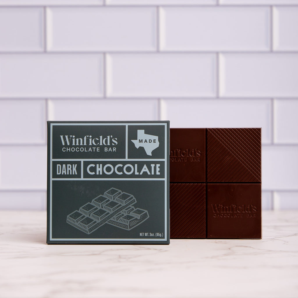 Winfield's solid Dark Chocolate bar in its charcoal wrapper beside the unwrapped bar