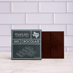Winfield's solid Dark Chocolate bar in its charcoal wrapper beside the unwrapped bar