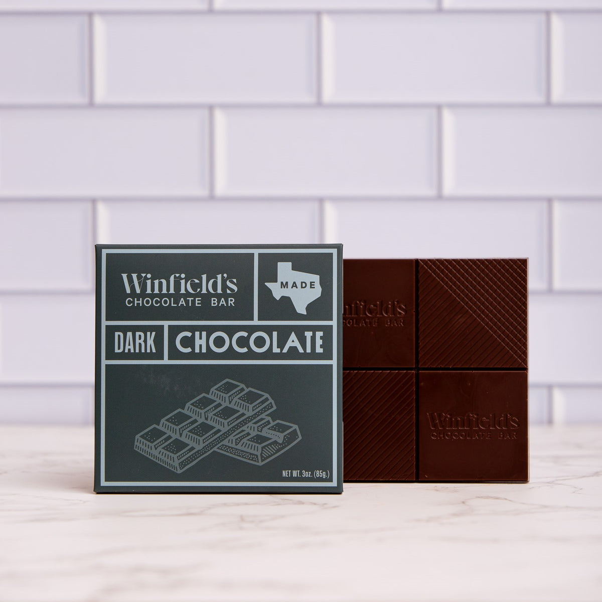 Winfield's solid Dark Chocolate bar in its charcoal wrapper beside the unwrapped bar