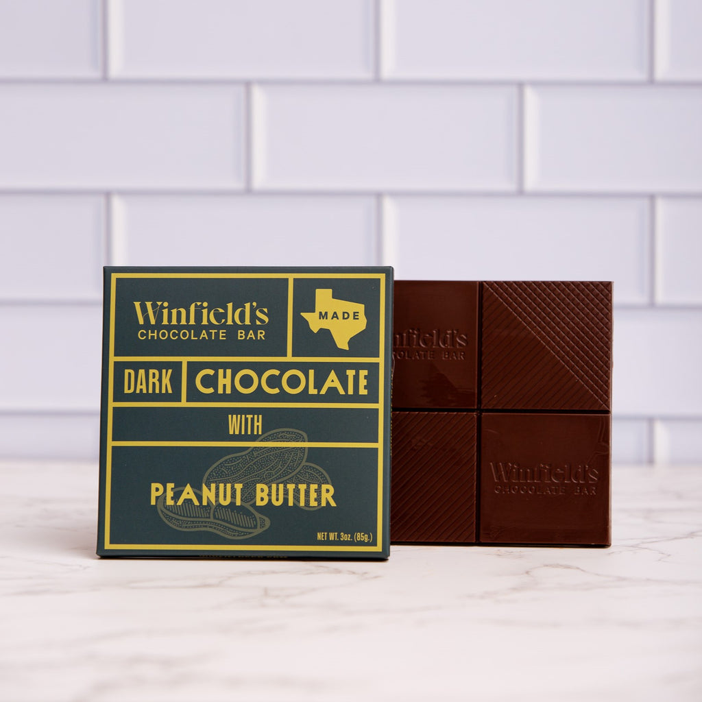 Winfield's Dark Chocolate with Peanut Butter bar in its yellow and charcoal wrapper beside the unwrapped bar