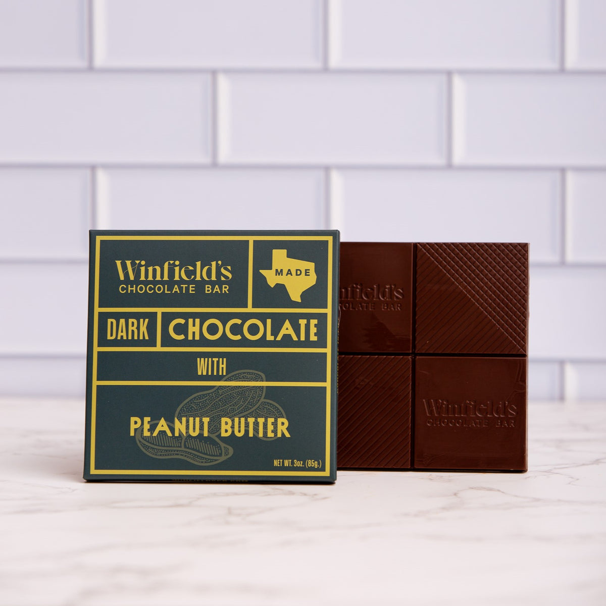 Winfield's Dark Chocolate with Peanut Butter bar in its yellow and charcoal wrapper beside the unwrapped bar