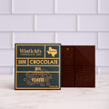Winfield's Dark Chocolate with Toffee bar in its navy and gold wrapper beside the unwrapped bar