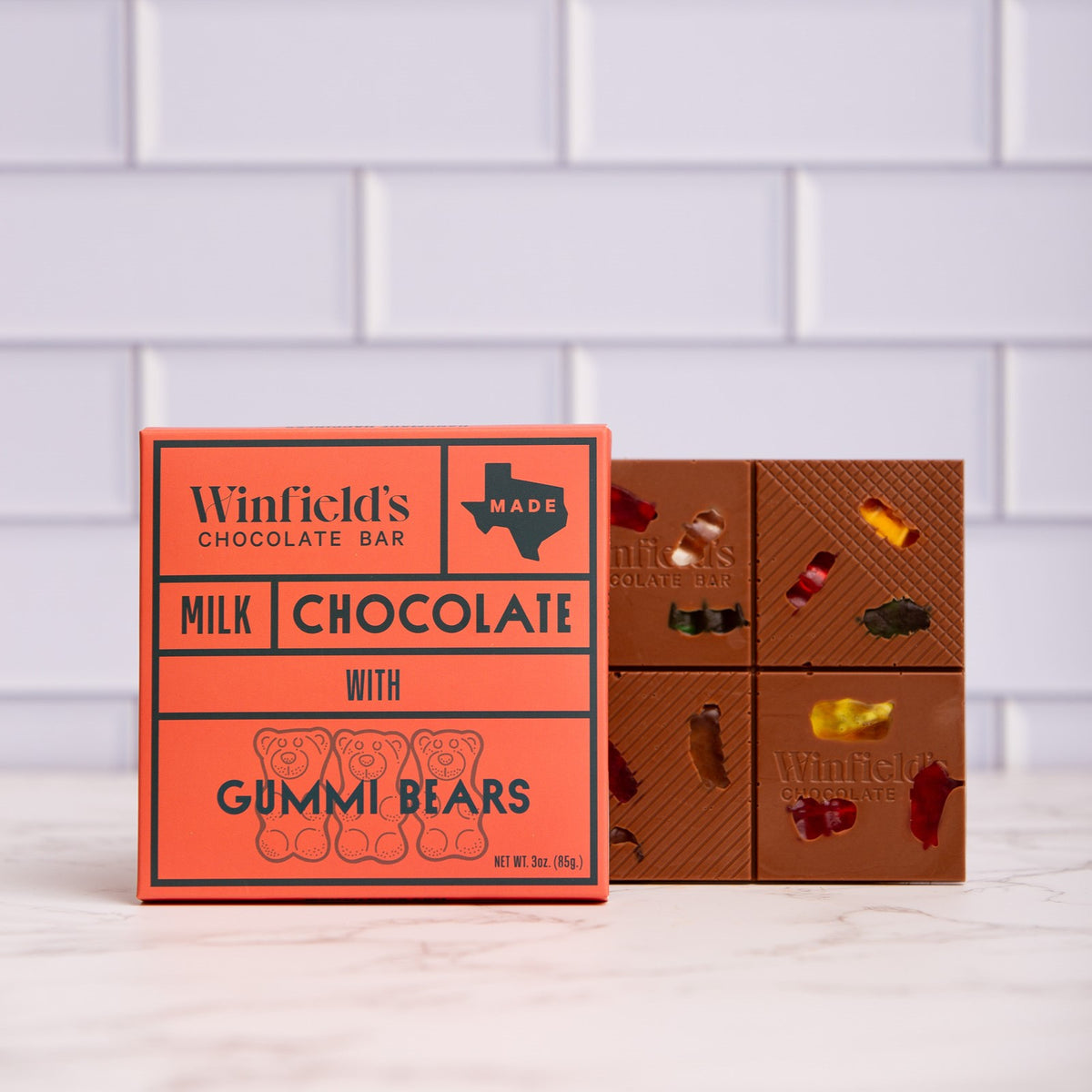 Winfield's Milk Chocolate with Gummi Bears bar in its orange wrapper beside the unwrapped bar studded with gummy bears