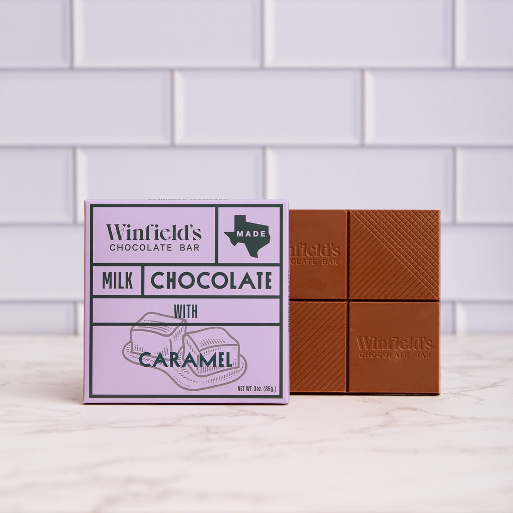 Winfield's Milk Chocolate with Caramel bar in its lilac wrapper beside the unwrapped bar