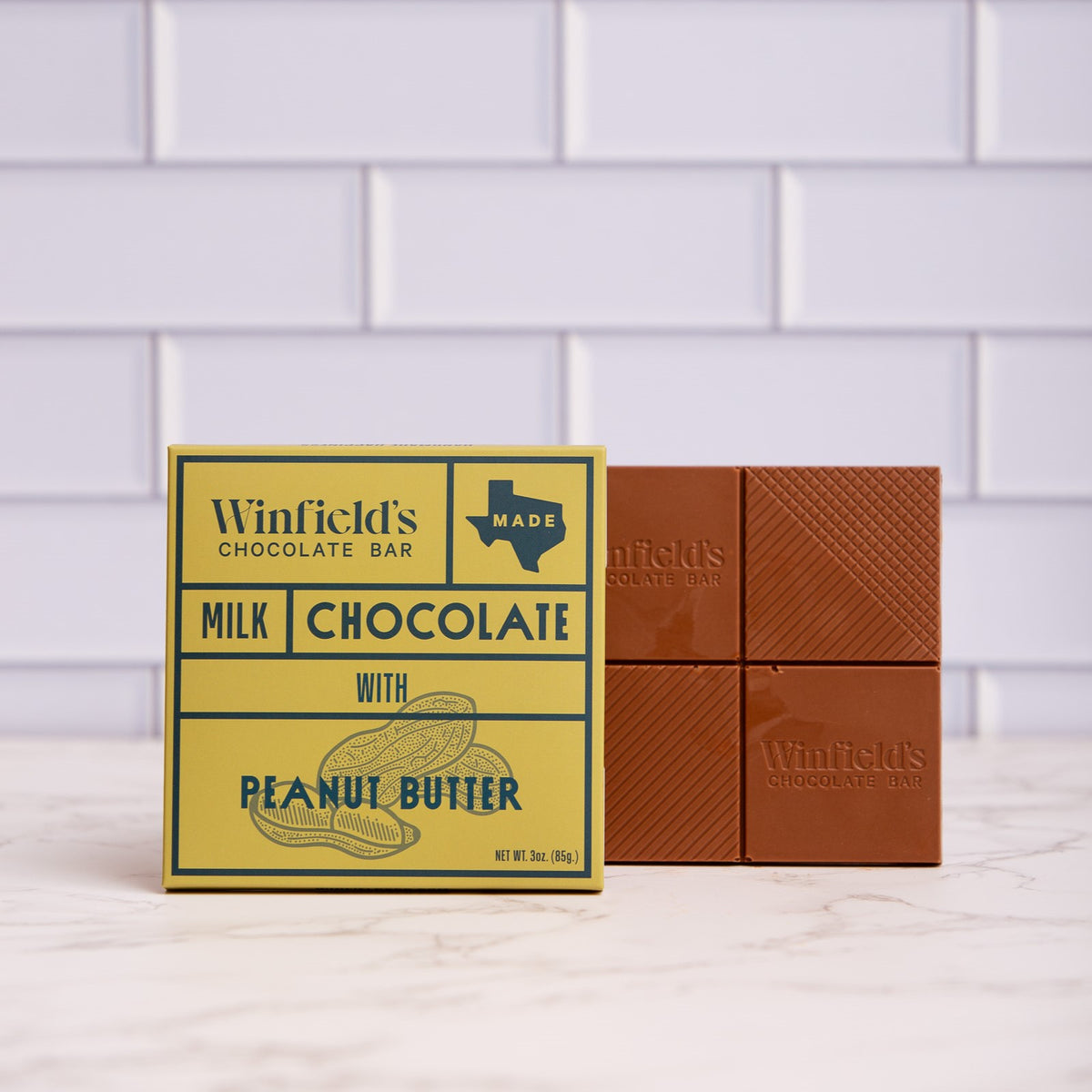 Winfield's Milk Chocolate with Peanut Butter bar in its yellow wrapper beside the unwrapped bar