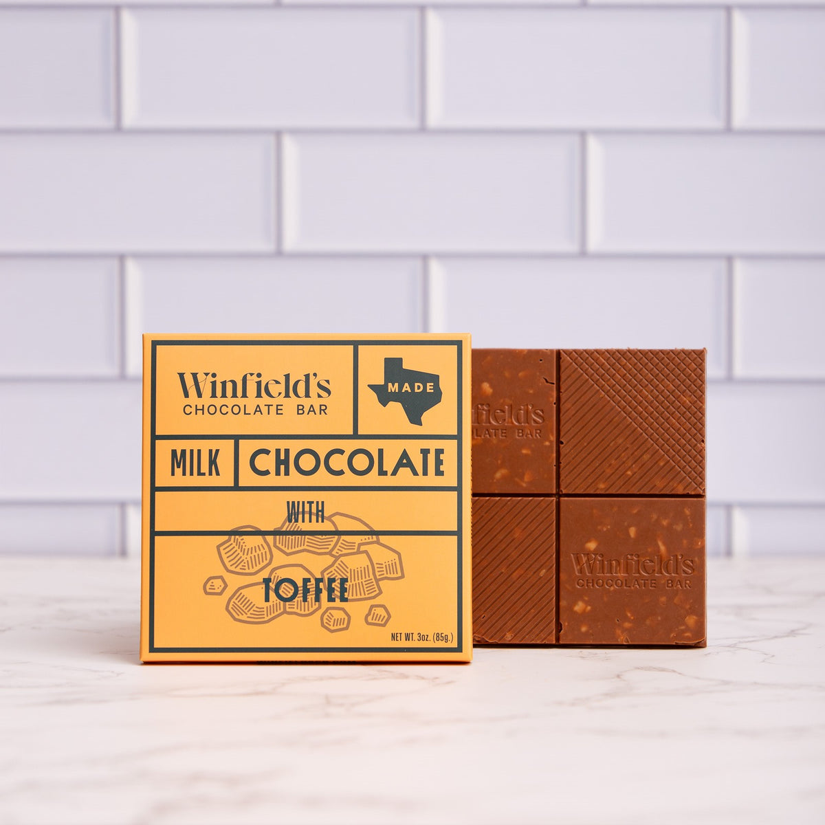 Winfield's Milk Chocolate with Toffee bar in its yellow wrapper beside the unwrapped bar