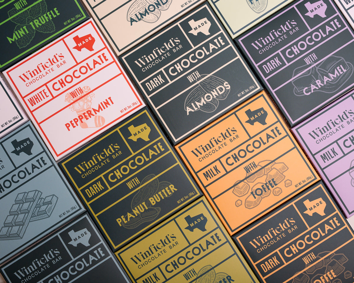 Winfield's chocolate bar wrappers tiled edge to edge, showing the full run of flavours from mint truffle and almonds to peanut butter and toffee