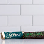 Winfield's Dark Chocolate Dubai Bar in its teal wrapper beside the unwrapped bar