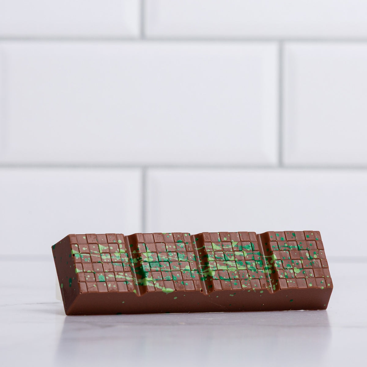 Unwrapped Winfield's Milk Chocolate Dubai Bar showing the green pistachio and kataifi filling