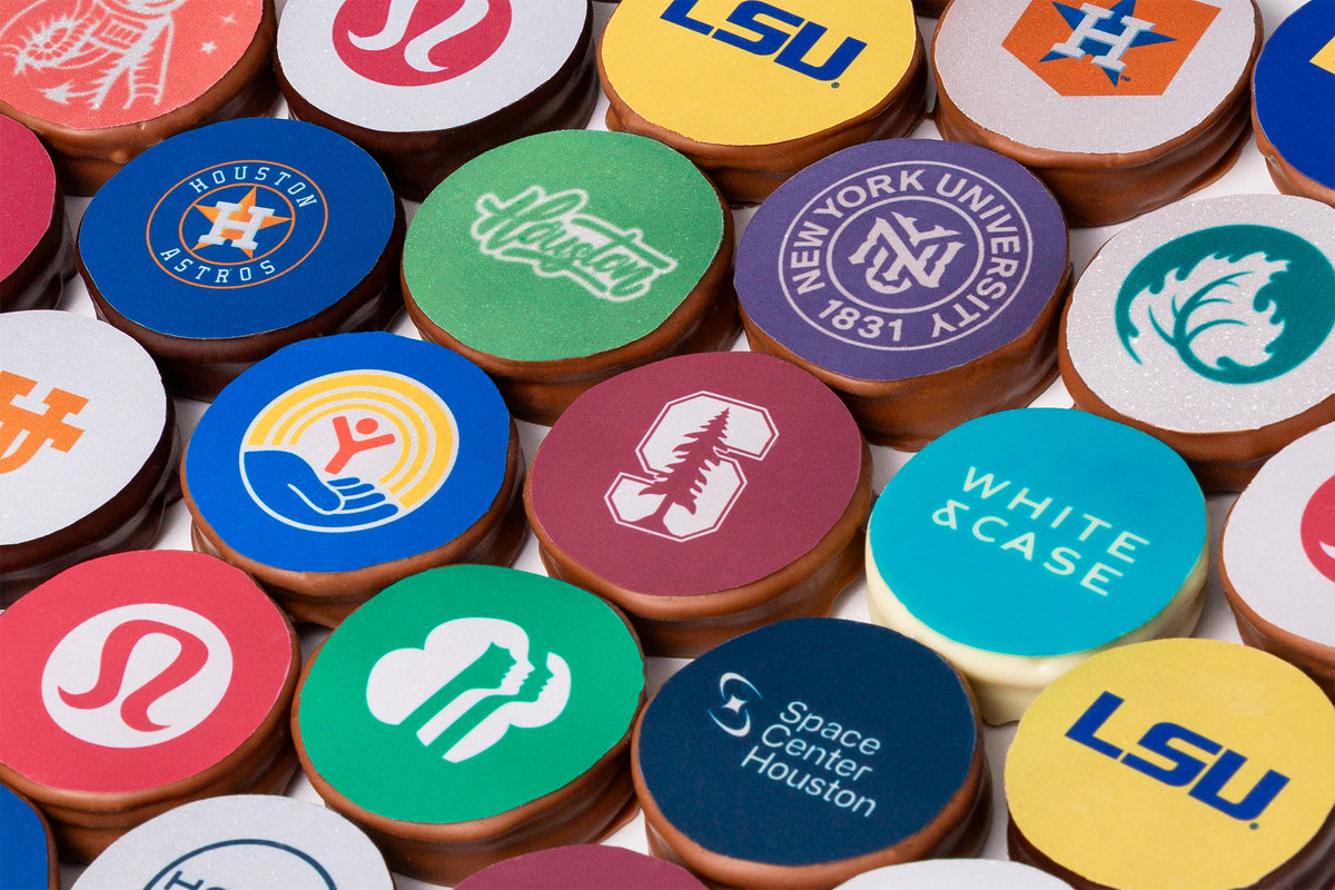 A grid of Winfield's chocolate-covered Oreos, each topped with a different university or corporate logo