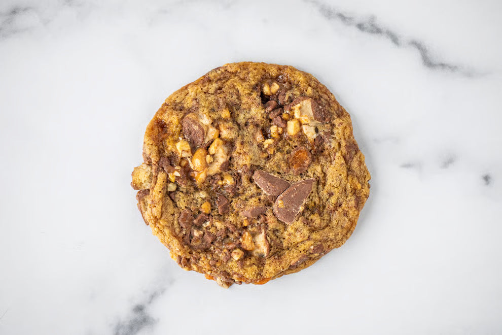 A Winfield's cookie studded with chocolate chunks on a marble counter