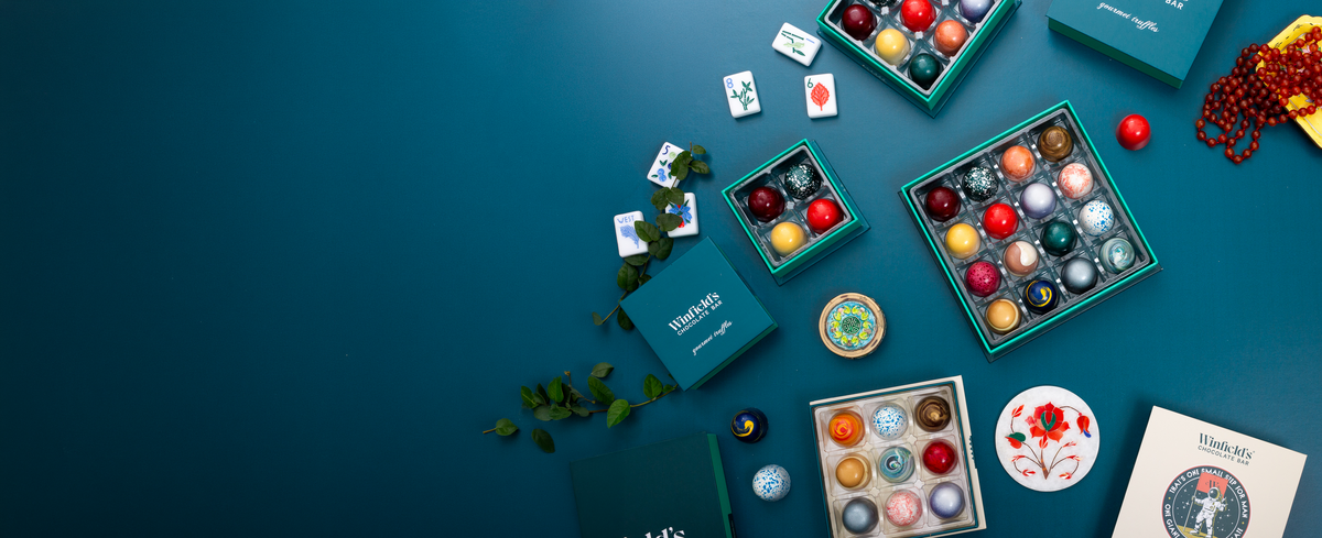 Winfield's truffle boxes and loose truffles arranged on a deep blue background