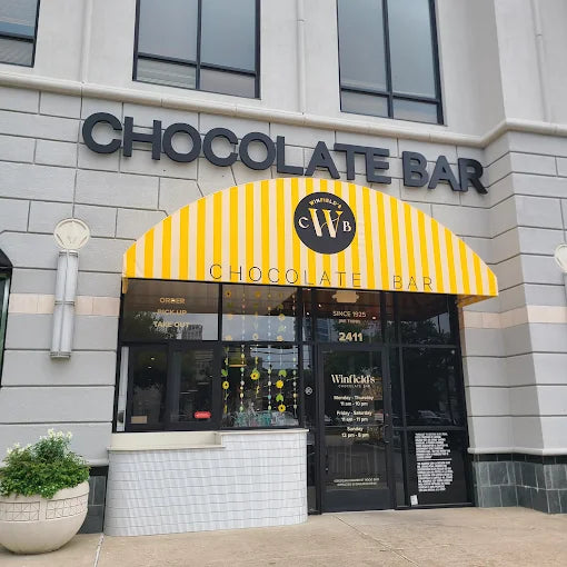 The Winfield's Chocolate Bar storefront in River Oaks, CHOCOLATE BAR lettering above a yellow striped awning