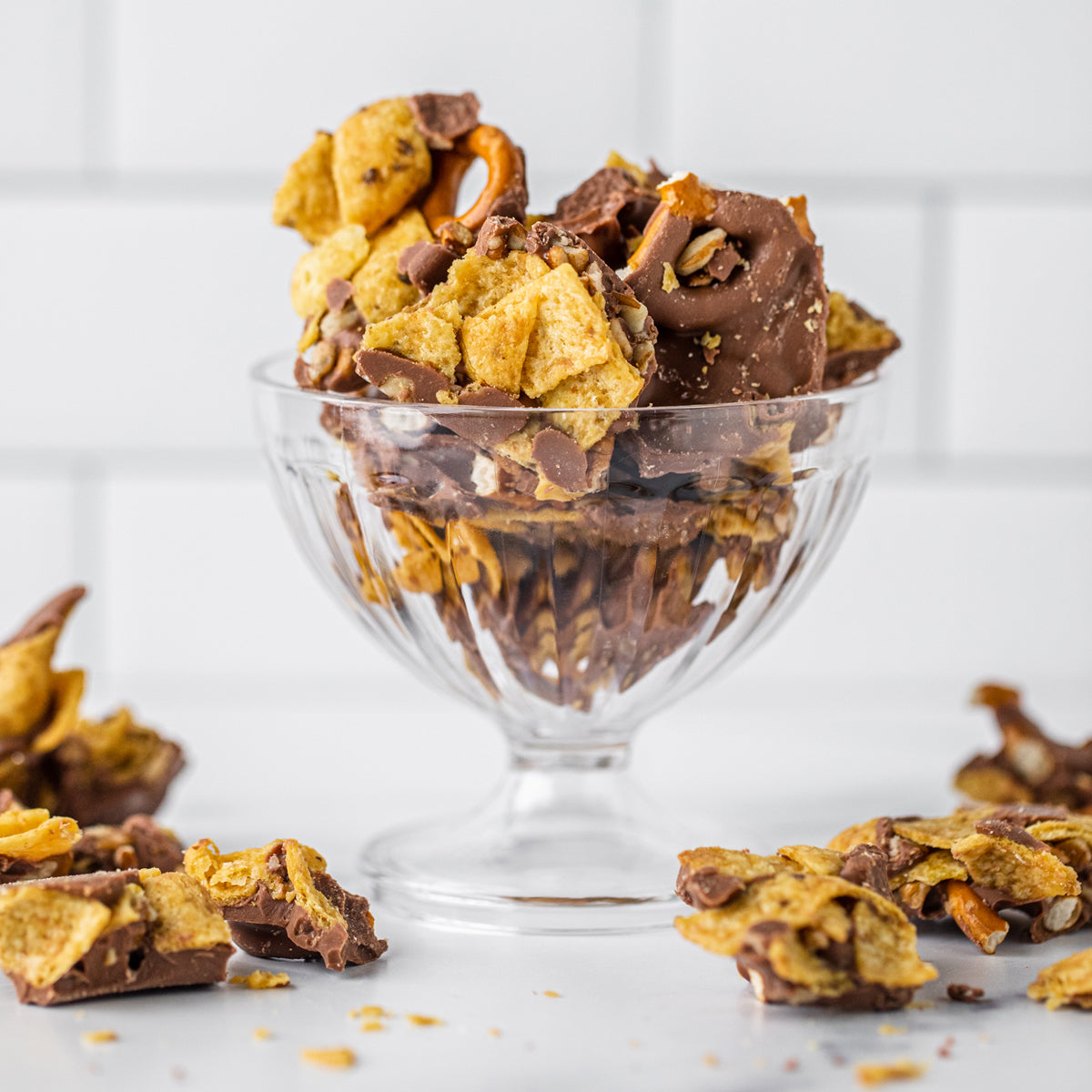 Winfield's Texas Frito Brittle piled in a footed glass dish, broken pieces scattered alongside